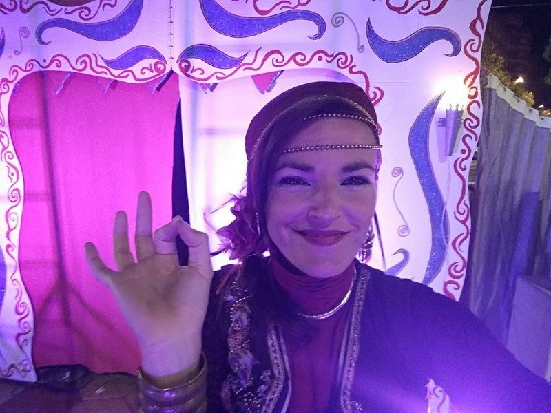 Araceli Lozano caracterizada para una sesión de cuentos, delante de un decorado en tonos violetas