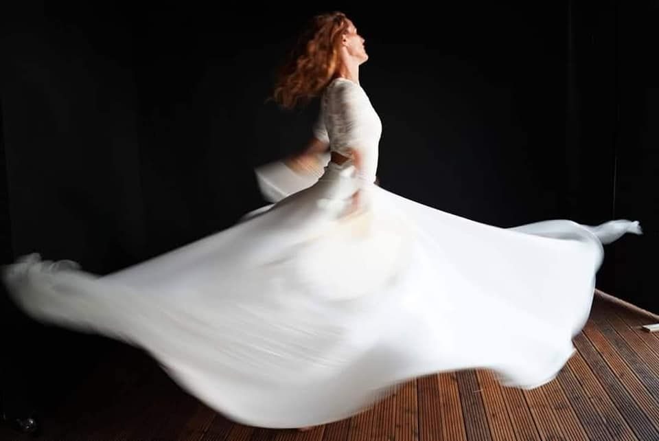 Araceli girando con un vestido blanco, en un giro derviche