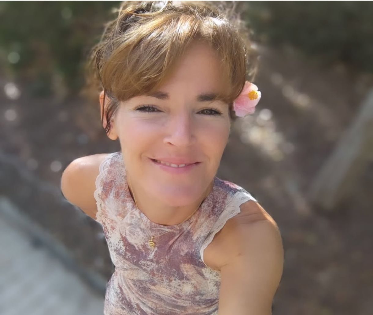 Araceli sonriendo, con una flor en el pelo