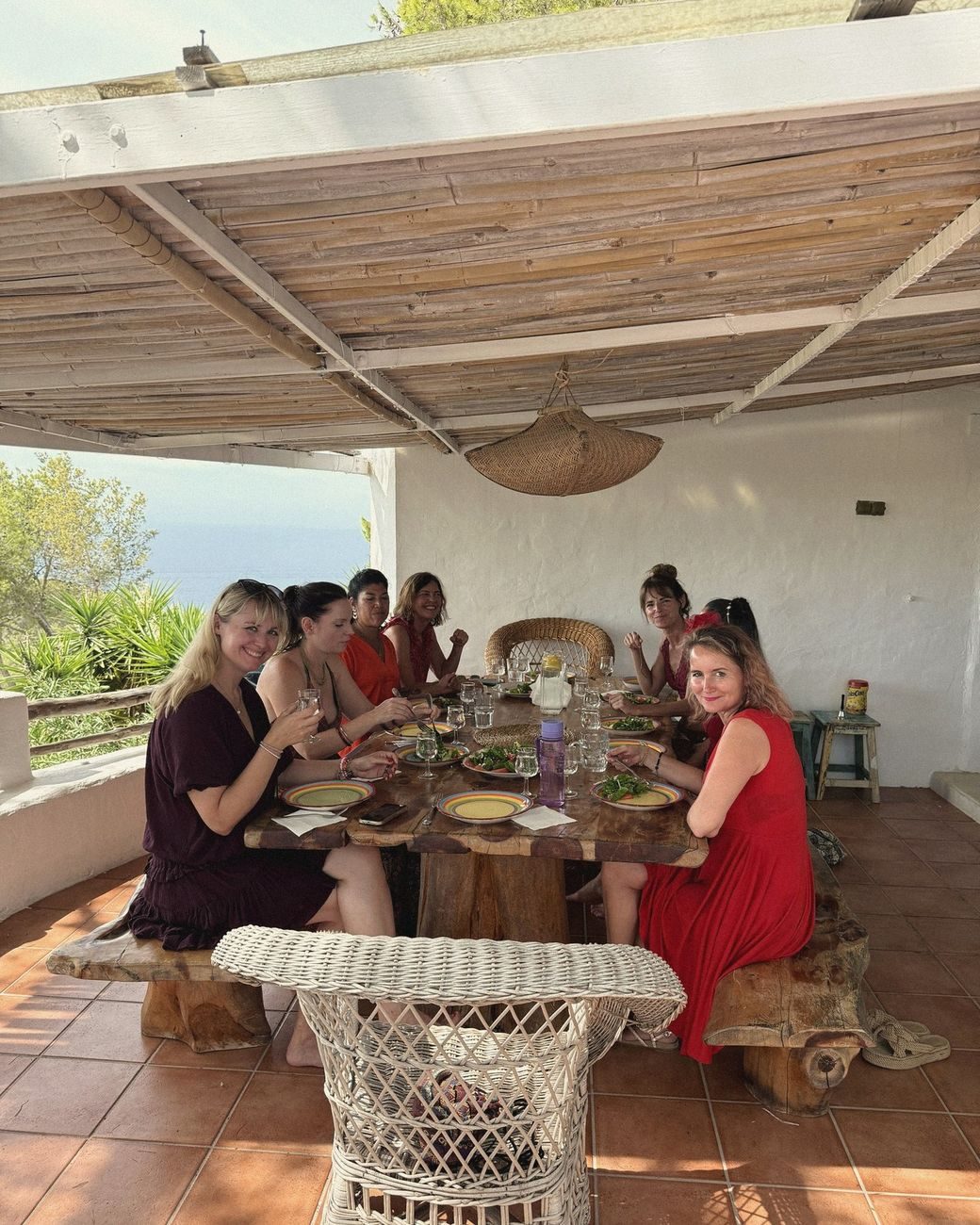 Mujeres compartiendo la comida en una terraza con vistas al mar
